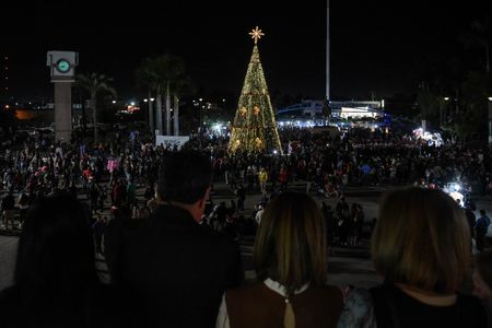 Con el propósito de recibir el mes de diciembre y la temporada navideña con la mejor actitud, Cajeme se iluminó con esperanza y buenos deseos gracias al tradicional desfile que recorre las calles del municipio y el gran encendido del árbol navideño, convocando a cientos de personas en la plaza Álvaro Obregón. La celebración inició con la presentación del coro del Instituto Schiller y los grupos de ITESCA, Rondalla voces del tiempo y La Tuna, que animaron la velada con villancicos y buena música, para después dar paso al evento protocolario encabezado por el presidente municipal, Javier Lamarque y su esposa, la presidenta del voluntariado de DIF Cajeme, Patricia Patiño. "Es importante recordar que la navidad es un festejo que brota del corazón, y la felicidad que nos brinda es fruto de la voluntad de compartir el amor, de la empatía para ayudar al prójimo y cuidar de nuestros seres queridos", expresó su alegría el Alcalde después de ver a toda la comunidad reunida. La presidenta de DIF Cajeme, Patricia Patiño, también compartió sus bendiciones con todas las personas convocadas. "El día de hoy inicia oficialmente la Navidad Mágica en Cajeme al encender juntos nuestro árbol navideño, una época para promover la paz, el amor y la alegría en nuestra comunidad, recordando que queremos un Cajeme seguro para todas las niñas, los niños y nuestras familias" expresó con gran emoción. Finalmente se realizó el conteo para encender el árbol de navidad en compañía de José Ricardo, Loretta, Marco y Ernesto, en representación de todas las niñas y los niños de Cajeme, para iluminar toda la plaza con sus bellas luces,
